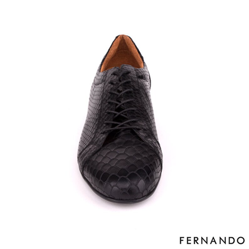 以下が含まれることがあります： ヘビ柄のブラックレザーレースアップシューズ