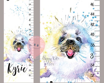 以下が含まれることがあります： カラフルな水しぶきを背景に、かわいいアザラシの赤ちゃんを描いた水彩画。イラストは、「Watch me grow」という文字と、「Kyrie」という名前が黒色の筆記体で書かれた身長測定表の一部です。身長測定表は、66 cmから127 cmまで測定できます。