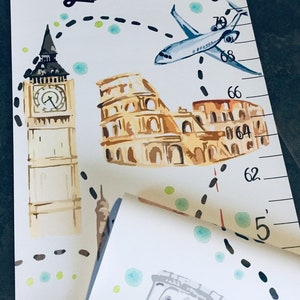 Puede incluir: Un medidor de altura de lona blanca con colgador de madera, que muestra el nombre Liam, ilustraciones en acuarela del Big Ben, el Coliseo y un avi&oacute;n, con una ruta de vuelo punteada y una escala vertical marcada en pies y pulgadas.