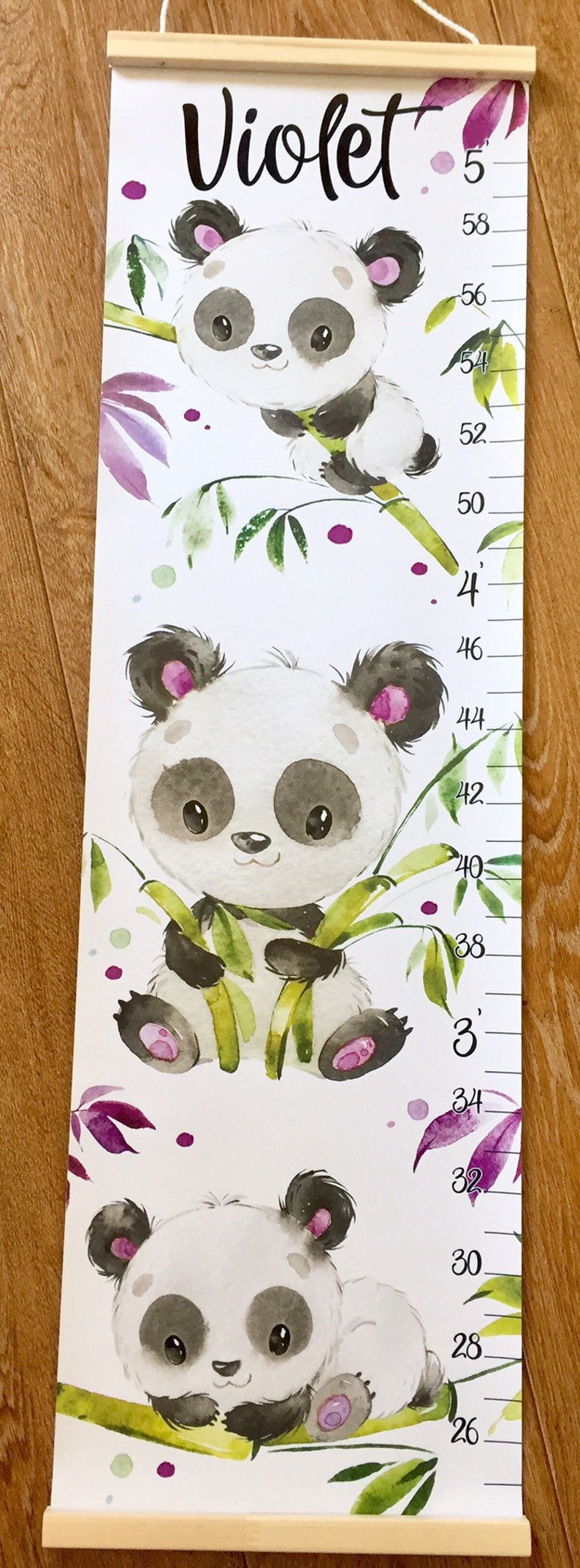 May include: A white growth chart with a panda bear design. The chart features three pandas holding bamboo stalks. The chart is labeled with the name "Violet" and has measurements in inches from 26 to 58.