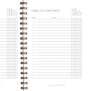 May include: A white spiral-bound notebook with a "Table of Contents" page. The page includes sections for page numbers and titles, with columns for "Other," "Desserts," "Breads," "Meats/Mains," "Salads/Sides," and "Appetizers."