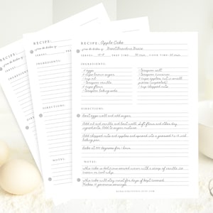 May include: Printable recipe cards with a handwritten recipe for Apple Cake. The recipe includes ingredients like brown sugar, flour, vanilla, and apples. The cards have a gray border and are printed on white paper.
