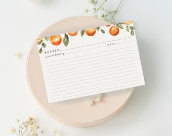 Pode incluir: Um cartão de receitas retangular branco com uma ilustração em aguarela de laranjas e folhas verdes ao longo da borda superior. O cartão inclui linhas impressas para escrever, com o texto RECIPE, SERVES e from the kitchen of.