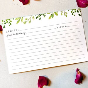 K&ouml;nnte beinhalten: Eine leere Rezeptkarte mit gr&uuml;nem Aquarell-Blumenrand. Die Karte hat Linien zum Aufschreiben eines Rezepts und enth&auml;lt den Text "REZEPT: aus der K&uuml;che von..." und "PORTIONEN:"