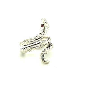 May include: Silver snake ring with a red gemstone eye. The snake is coiled and the head is raised.