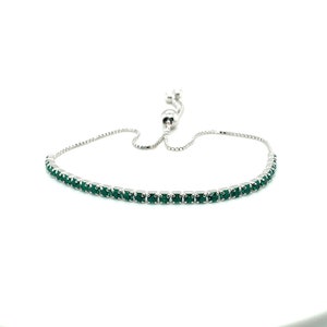 Puede incluir: Un brazalete ajustable de plata con una fila de piedras preciosas verde oscuro.