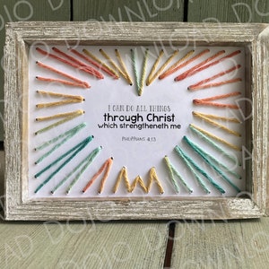 Puede incluir: Una pieza de bordado enmarcada con una forma de corazón creada con hilos de colores. El texto dentro del corazón dice "Puedo hacer todas las cosas por medio de Cristo que me fortalece Filipenses 4:13".