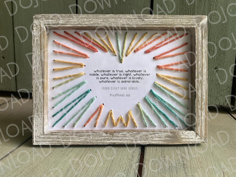 K&ouml;nnte beinhalten: Eine gerahmte Stickerei mit wei&szlig;em Hintergrund und buntem Garn in einem Regenbogenmuster. Die Stickerei zeigt das Zitat "Was immer wahr ist, was immer edel ist, was immer gerecht ist, was immer rein ist, was immer liebenswert ist, was immer bewundernswert ist... Denkt an solche Dinge. Philipper 4,8"