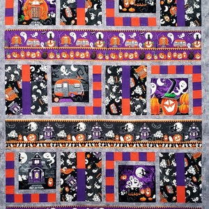 May include: A Halloween-themed quilt with a patchwork design featuring various images of ghosts, pumpkins, and houses. The quilt is made with a variety of fabrics in shades of gray, purple, orange, and black.