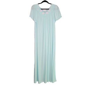 May include: A light blue nightgown with a floral embroidered neckline. The gown has short sleeves and a flowing silhouette.