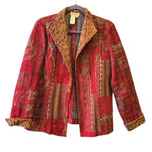 May include: A long-sleeve jacket featuring a vibrant red base with a multi-colored tapestry-style pattern. The garment includes a wide lapel and sleeve cuffs with a brown and black leopard print design. The interior label reads Coldwater Creek.