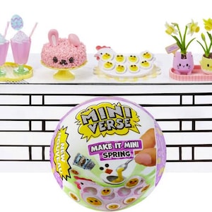 May include: A miniature playset featuring a pink cake, two milkshakes, a chicken with eggs, and two potted plants. The set is displayed on a white countertop with a black brick pattern. The set is part of the MGA's Miniverse Make It Mini Spring collection.