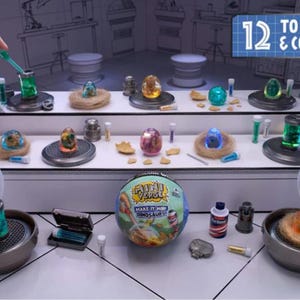 Pode incluir: Um conjunto de jogos com tema científico com ovos de dinossauro, frascos e recipientes. O conjunto inclui um globo com o texto "Make It Mini Dinosaurs". A imagem também mostra o texto "12 To Make & Collect".