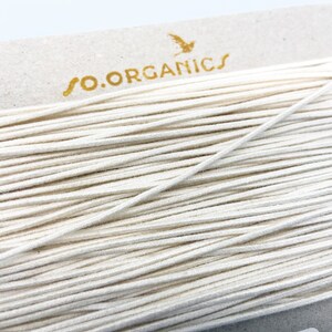 May include: A spool of white elastic cord with the text "so.organics" printed on the label.