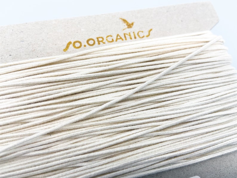 May include: A spool of white elastic cord with the text "so.organics" printed on the label.
