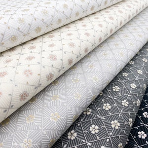 Może przedstawiać: Zbliżenie na cztery próbki tkaniny z różnymi wzorami geometrycznymi. Próbki są w odcieniach szarości, bieli i czerni z subtelnym wzorem kwiatowym.