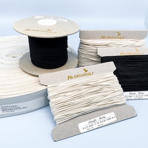 May include: Three spools of organic cotton cord, one black and two ecru, with labels that read "JO.ORGANICS" and "Charle - Berlin".