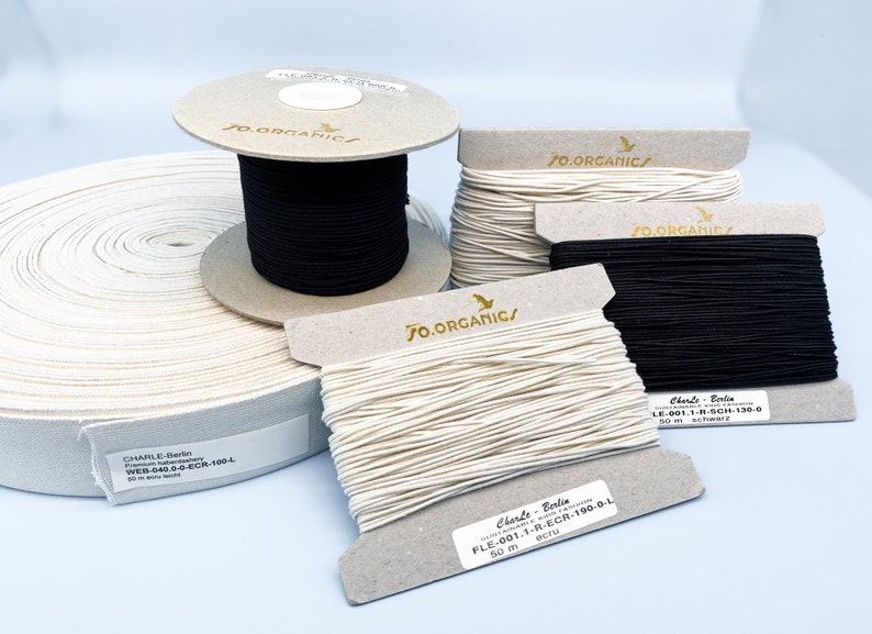 May include: Three spools of organic cotton cord, one black and two ecru, with labels that read "JO.ORGANICS" and "Charle - Berlin".