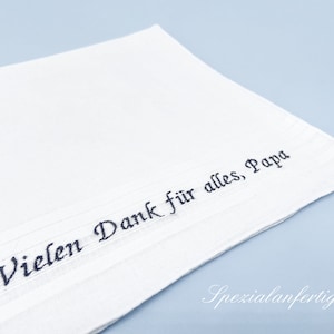 Könnte beinhalten: Weißes Taschentuch mit schwarzem Sticktext "Vielen Dank für alles, Papa".
