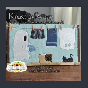May include: A Kinusaiga pattern craft project featuring a light blue background with a white ghost hanging laundry on a line. The scene includes plaid shorts, a blue towel, a white sheet, a tan basket, and a black cat silhouette. Text reads Kinusaiga Pattern, All of my patterns are drawn by hand never AI, Front Porch Studio, Digital Download, Basic Instructions Included.