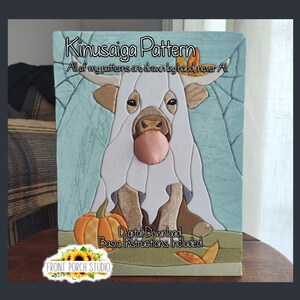 May include: A Kinusaiga pattern craft project featuring a white highland cow with a pink nose, a pumpkin, and autumn leaves. The text reads Kinusaiga Pattern, All of my patterns are drawn by hand never AI, Digital Download, Basic Instructions Included.