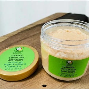 May include: A jar of turmeric exfoliating body scrub with a green label and a gold lid. The label reads "Turmeric Exfoliating Body Scrub" and "Enriched with Argan oil, Jojoba oil & Patchouli oil". The jar contains 567 grams of product.