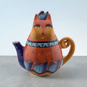 May include: A set of three ceramic mugs with a speckled, matte finish. The mugs are in shades of cream, light gray, and dark gray. Each mug has a simple, minimalist design, perfect for coffee or tea.