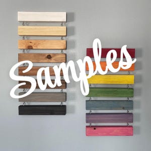 May include: Samples of different wood stains on wooden planks. The stains range in color from white to red, yellow, green, blue, purple, and pink.