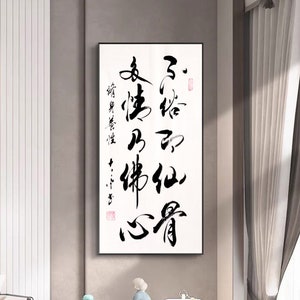 May include: Black and white calligraphy art print featuring Chinese characters on a white background. The print is framed in a black frame and is hanging on a wall in a modern living room.