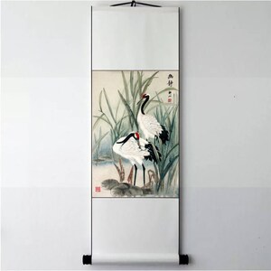 Puede incluir: Una pintura tradicional china sobre un rollo de seda que representa dos grullas blancas con puntas de alas negras de pie en un pantano con juncos verdes. La pintura est&aacute; firmada con caracteres chinos.