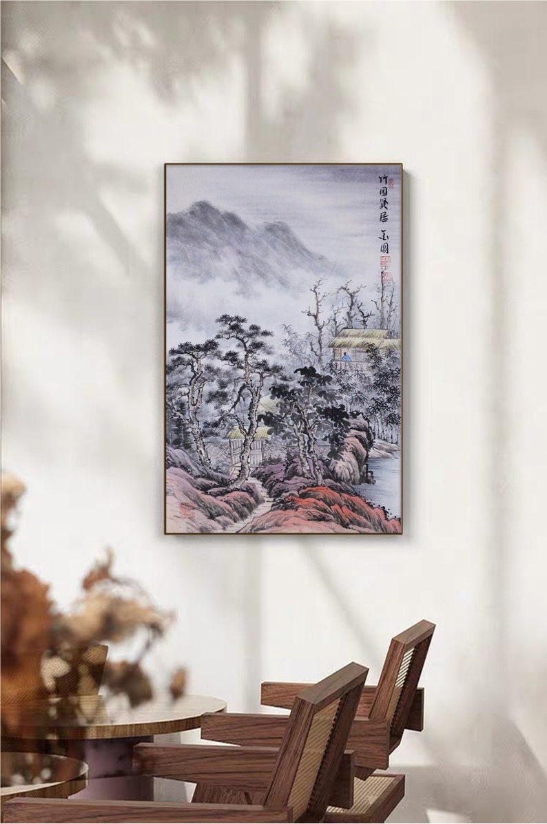 May include: A framed painting of a misty mountain landscape with a small village in the foreground. The painting is in shades of gray, blue, and pink, with a few touches of green. The text "竹田 庄司" is written in the upper right corner of the painting.