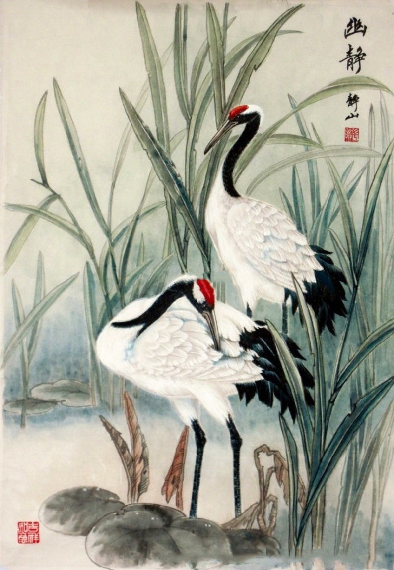 Puede incluir: Una pintura tradicional china que representa dos grullas blancas con marcas negras y rojas de pie en un pantano con juncos verdes. La pintura est&aacute; firmada con caracteres chinos.