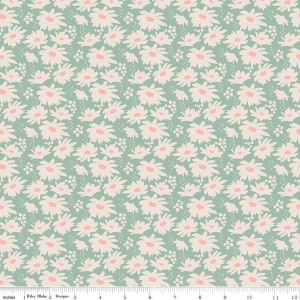 May include: A fabric with a repeating floral pattern. The design features white daisy-like flowers with pink centers and small white clusters on a light teal background. The image includes a ruler with inches.