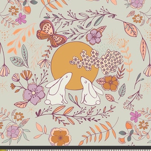 Könnte beinhalten: Ein hellgrüner Stoff mit einem skurrilen Design mit zwei weißen Kaninchen, einem Schmetterling, Blumen und Blättern. Das Design umfasst eine gelbe Sonne und ist mit Orange-, Lila- und Pfirsichtönen akzentuiert. Der Stoff wird mit einem Lineal gemessen.