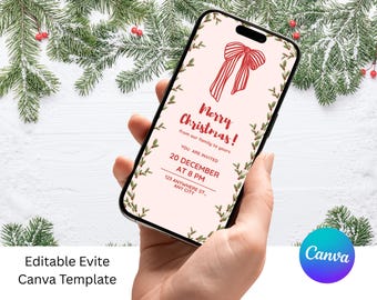 Peut inclure: Un smartphone affiche une invitation de Noël avec une illustration de nœud rouge et le texte "Merry Christmas!" entouré de feuilles vertes. L'invitation comprend la date, l'heure et l'adresse. Le téléphone est tenu devant un fond de branches de pin enneigées.