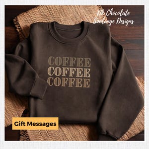 May include: A brown sweatshirt with the word "COFFEE" printed three times in a stacked design. The text is in a light brown colour with a subtle striped pattern.