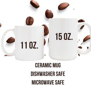 K&ouml;nnte beinhalten: Zwei wei&szlig;e Keramikbecher mit schwarzem Text. Der kleinere Becher ist 11 oz und der gr&ouml;&szlig;ere Becher ist 15 oz. Beide Becher sind sp&uuml;lmaschinen- und mikrowellengeeignet.