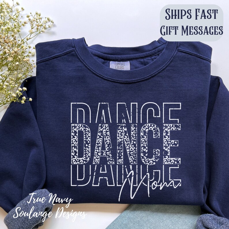 Peut inclure: Sweat-shirt bleu marine avec un motif blanc qui dit "Dance Mom" avec le mot "Dance" r&eacute;p&eacute;t&eacute; trois fois dans un motif l&eacute;opard.