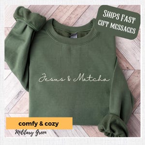 May include: A green sweatshirt with the text "Jesus & Matcha" in white cursive lettering. The sweatshirt is made of a soft, comfortable material and has a relaxed fit.