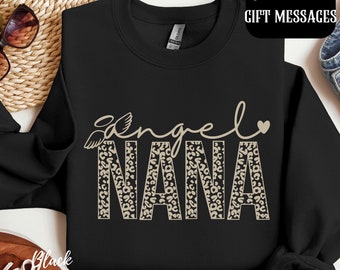 Può includere: Felpa nera con un design a stampa leopardata marrone che dice "angel nana" con un piccolo cuore.