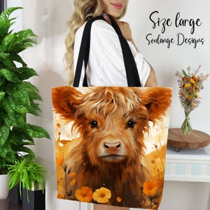 May include: A large tote bag featuring a close-up of a Highland cow with a soft, fuzzy brown coat. The cow is looking directly at the viewer with big, brown eyes. The background is a watercolor-style painting of yellow flowers.