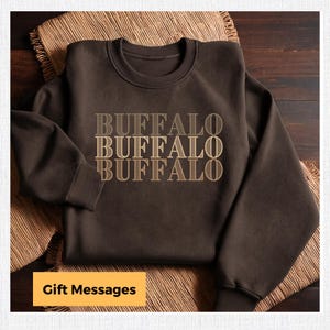 May include: A brown sweatshirt with the word "BUFFALO" printed on it three times in a gradient of brown shades.