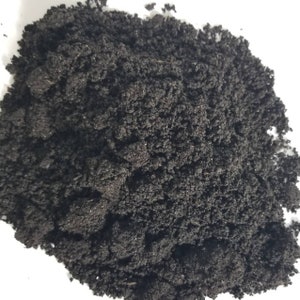 May include: A close-up of a pile of dark brown, crumbly soil. The soil is rich and fertile, perfect for planting seeds or growing plants.