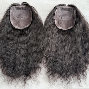 Pode incluir: Duas peças de cabelo crespo preto com um design de clip. As peças de cabelo estão sobre uma superfície branca.