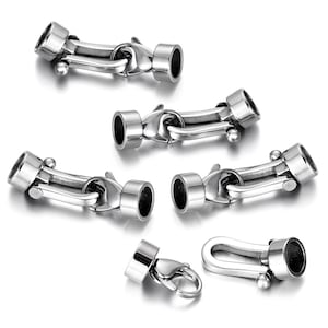 May include: Five silver-toned metal clasps for jewelry making. The clasps have a hook and loop design with a small ball on the end. One clasp has a lobster claw design.