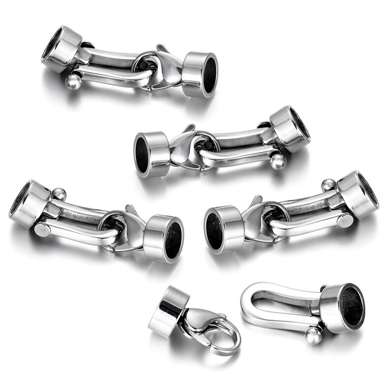 May include: Five silver-toned metal clasps for jewelry making. The clasps have a hook and loop design with a small ball on the end. One clasp has a lobster claw design.