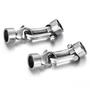 May include: Two silver-toned metal clasps with a round, cylindrical end piece. The clasps are designed to be used for jewelry making or other crafting projects.