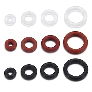 May include: Assortment of rubber O-rings in various sizes and colors. The O-rings are arranged in rows, showcasing a range of diameters. Colors include clear, red-brown, and black. These are commonly used for sealing and are made of flexible rubber.