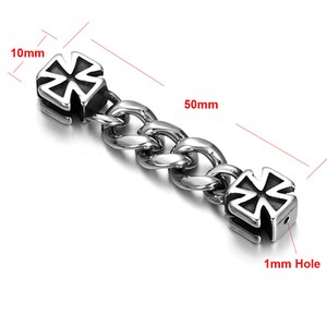 May include: A silver chain with two silver cross-shaped charms. The chain is 50mm long and the charms are 10mm wide. Each charm has a 1mm hole.