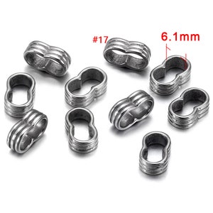 May include: Ten silver-toned metal spacer beads with a double-loop design. Each bead measures 6.1 mm in diameter. The beads are labeled #17.